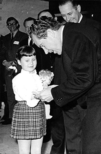 Foto vintage de Richard Nixon dando boneca para menina.